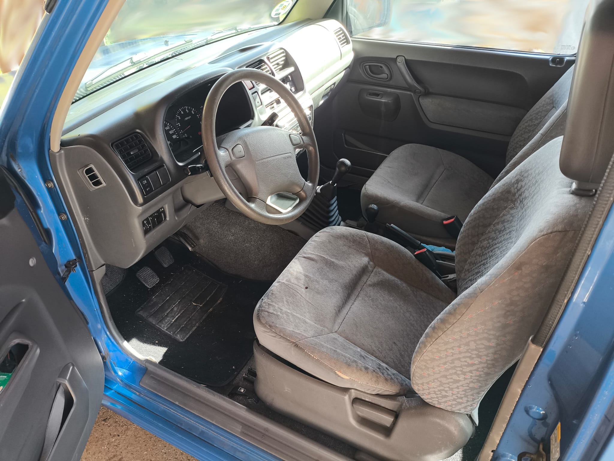 Cockpit con volante, consola central de tracción y asientos delanteros