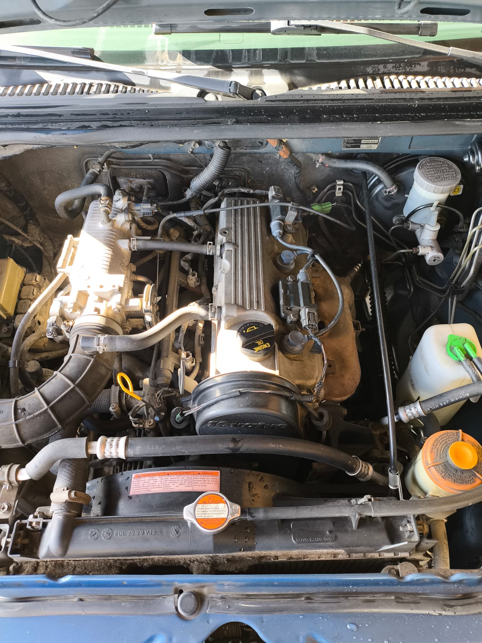Detalle central del motor mostrando tapa de válvulas y manguitos