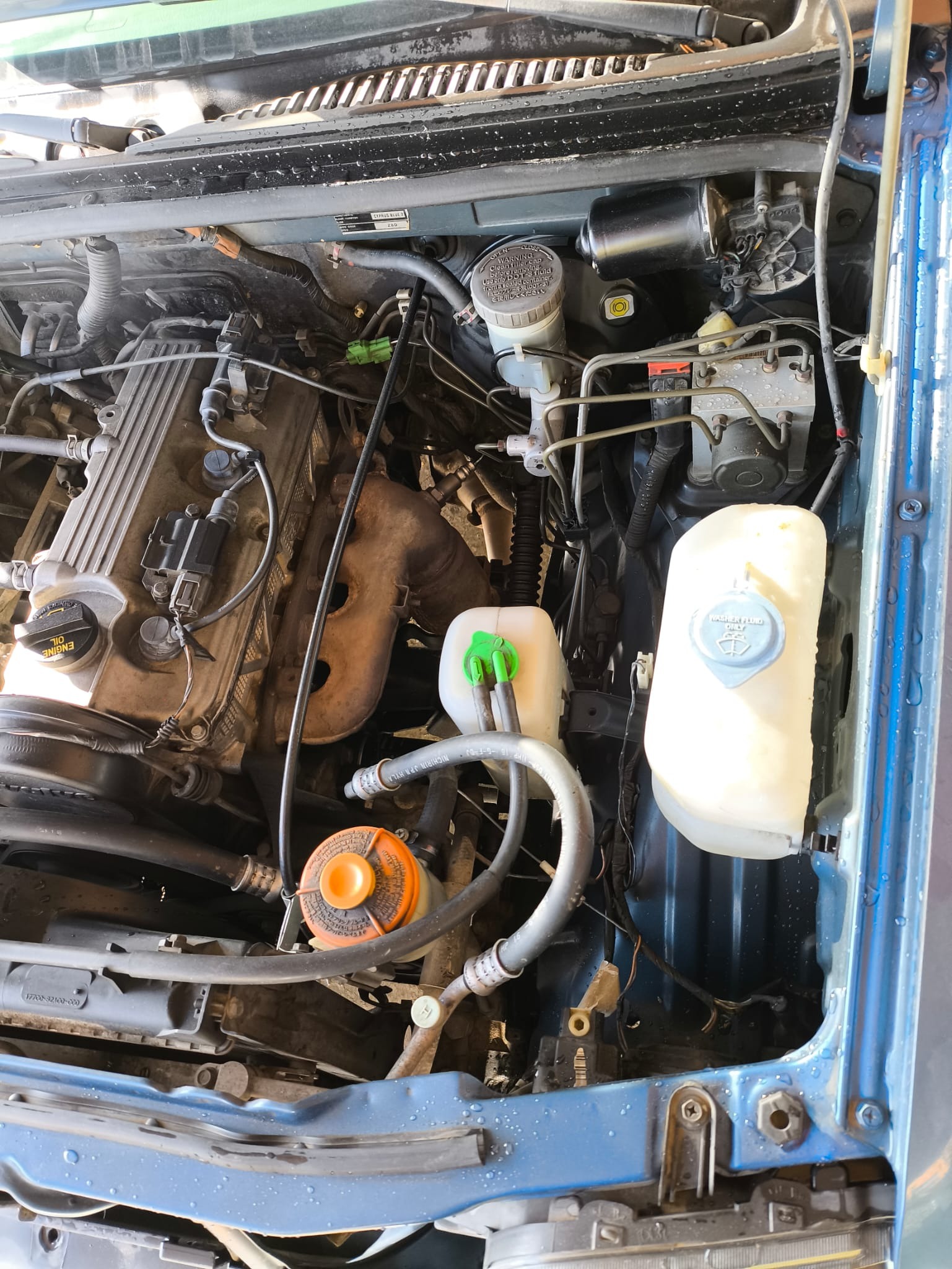Detalle lateral derecho del motor con depósito de líquido refrigerante y frenos